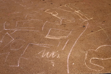 Children's chalk drawings on the sidewalk in the city.