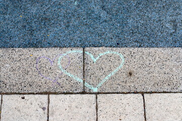 Children's chalk drawings on the sidewalk in the city.
