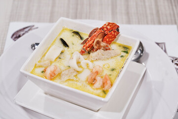 Creamy seafood soup. Crab, shrimp, squid, mussels and herbs in broth with coconut milk.