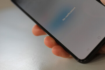 phone in hand with foggy white screen showing no notifications