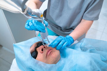 woman in a lab coat is treating a patient with a laser