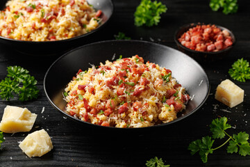 Carbonara fried rice with pancetta, pecorino romano cheese, eggs in a black bowl