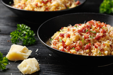Carbonara fried rice with pancetta, pecorino romano cheese, eggs in a black bowl