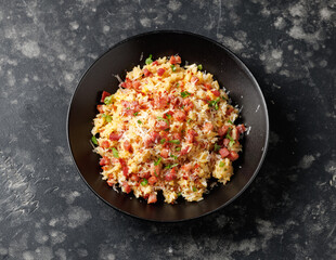 Carbonara fried rice with pancetta, pecorino romano cheese, eggs in a black bowl