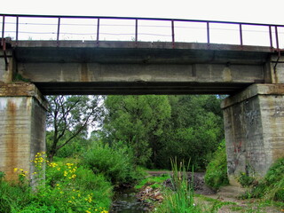 A picturesque stream flows under the railway bridge