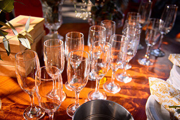 Empty champagne flutes on a beautiful sunny table. Catering service. Table setting, glass goblets, cutlery
