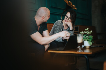 Two coworkers engaged in a business meeting, discussing strategy and teamwork in a modern coffee shop setting.