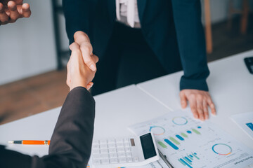 Handshake in agreement against young business people in board room meeting