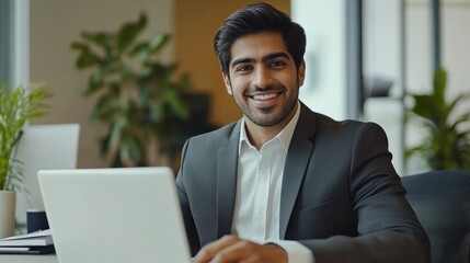 Indian happy smiling businessman ceo having working videocall on planning finance with multiracial team colleagues using laptop pc in modern corporation office. Over shoulder view.