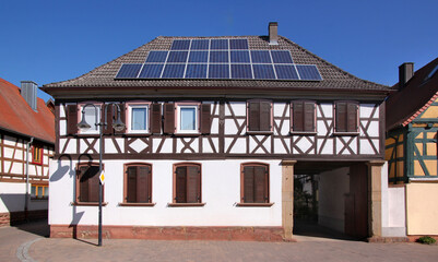 A half-timbered baroque residential house with solar collectors on its roof in the old village of Herxheim bei Landau, Pfalz region in Germany