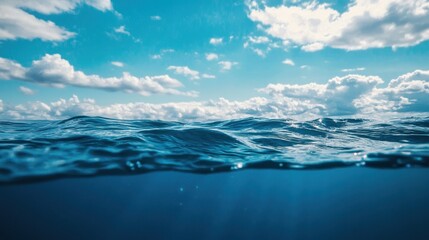 Blue sea or ocean water surface and underwater with sunny and cloudy sky