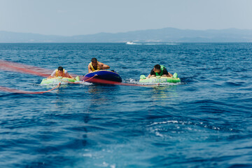 Summer fun with friends speedboat and tubing on the sea