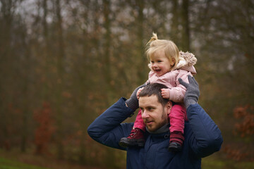A touching moment of father and daughter sharing a playful day in the park, perfect for content...