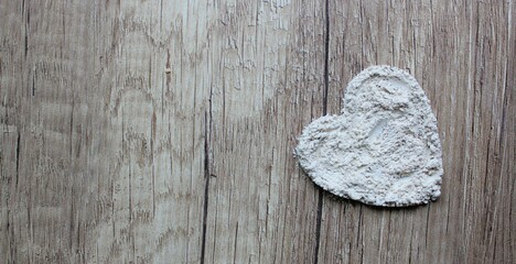Zeolite powder on a wooden board. Heart-shaped zeolites on a wooden background.