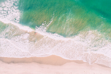 waves breaking on the shore of a beach at sunset, aerial top view with drone. Background for summer...