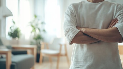 Man is standing with his arms crossed in a modern, minimalist living room, conveying a sense of confidence and ownership