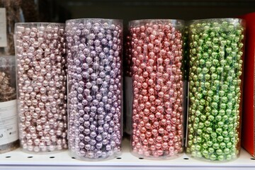 ribbon of beads in a transparent cylindrical flask, in a package, purple, pink, green balls on christmas shopping