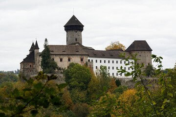 Restored castle ruins in autumn. View from the village. Sovinec. Czechia.