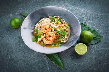 Authentical Asia style ramen noodle soup with prawns and cashew nuts served as close-up in a design...