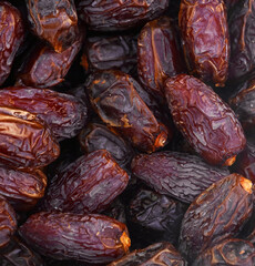 Close up of fresh medjool dates piled high, creating a textured background
