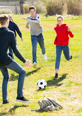 Teenagers play street football with excitement