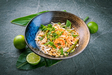 Authentical Asia style ramen noodle soup with prawns and cashew nuts served as close-up in a design...