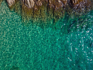 Aerial top down of rocks in blue water Mediterannean Sea along Costa Brava Palamos Catalonia