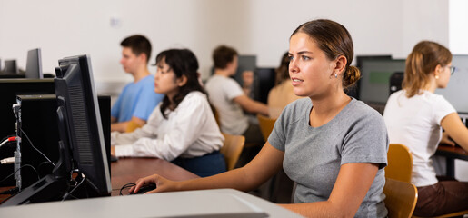 Teacher works at the computer in the classroom. Students doing programming