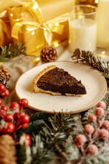 Delicious chocolate tart with Christmas decorations, surrounded by festive ornaments and holiday lights. Perfect dessert for Christmas, holiday gatherings, and winter celebrations.
