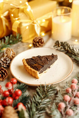 Delicious chocolate tart with Christmas decorations, surrounded by festive ornaments and holiday lights. Perfect dessert for Christmas, holiday gatherings, and winter celebrations.