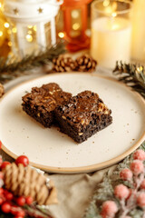 Festive Christmas brownie surrounded by holiday decorations, creating a cozy holiday vibe. Perfect for holiday season themes, Christmas treats, festive dessert spreads, and holiday celebration visuals