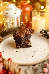 Festive Christmas brownie surrounded by holiday decorations, creating a cozy holiday vibe. Perfect for holiday season themes, Christmas treats, festive dessert spreads, and holiday celebration visuals