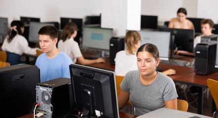 Fototapeta premium Teacher works at the computer in the classroom. Students doing programming