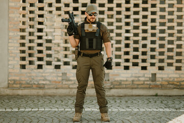 Soldier wearing tactical gear and holding a rifle posing confidently