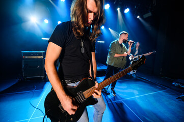 Obraz premium Guitarist performing live on stage with bandmates