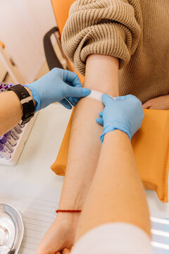 Healthcare professional applying a bandage after a blood draw procedure in a clinical setting