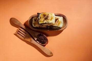 Banana bolen is made from banana and pastry skin and has chocolate and cheese filling. Served in wooden plate. Selective focus image.