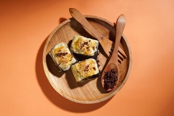 Banana bolen is made from banana and pastry skin and has chocolate and cheese filling. Served in wooden plate. Selective focus image.
