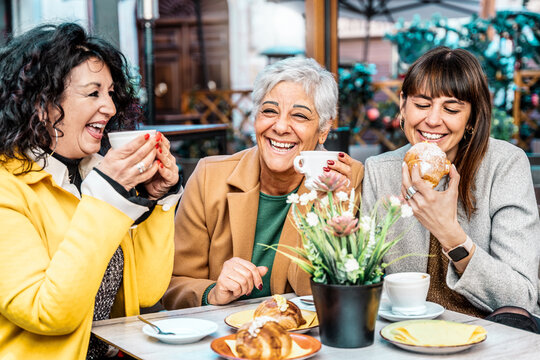 Group of happy older mature friends girls enjoying breakfast drinking coffee eat croissant at restaurant in city - Three senior women having fun at bar cafeteria - Joyful elderly lifestyle concept