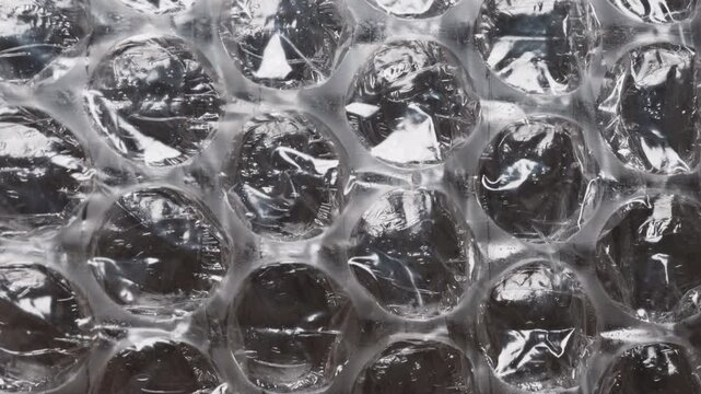 Slider. High-detail close-up of bubble wrap surface, showing individual air pockets and the transparent, flexible plastic used for secure product protection during shipping and handling.