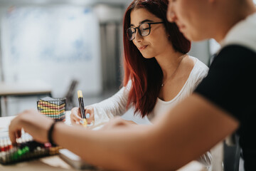 Two students focused on a creative task in their classroom. They are using colorful markers for their project, promoting learning and collaboration during their school session.