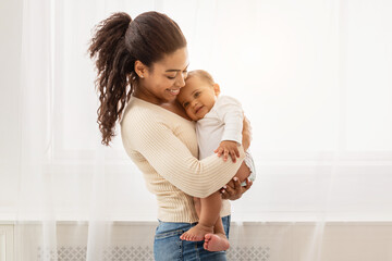 Loving African American Mother Holding Baby Cuddling Toddler In Arms Enjoying Motherhood And Child...