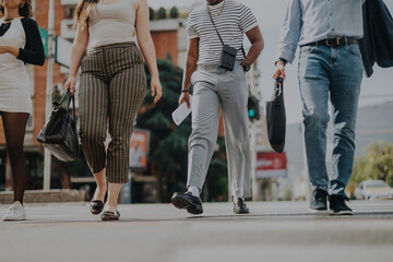 Obraz premium A group of diverse business people walk confidently in an urban area, symbolizing teamwork and collaboration. They are engaged in discussions about projects and strategies for growth.