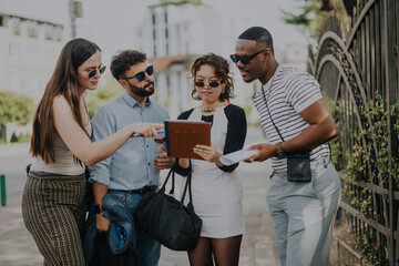 A diverse group of business people in an outdoor city setting, collaborating on projects. They are brainstorming ideas and strategizing to boost revenue and sales growth for their company.