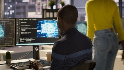Programmer creating AI machine learning models that can analyze data to automate decision making processes, handheld camera shot. IT professional doing artificial intelligence programming, camera A © DC Studio