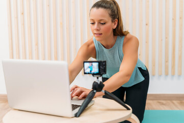 Sport vlogger preparing her online fitness class on laptop