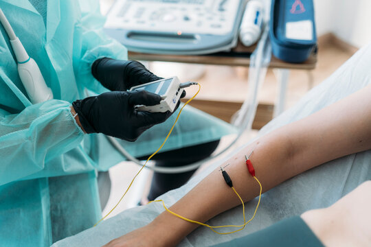 Doctor performing electromyography examination using needle electrodes