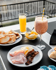 Breakfast table with juice, smoothie, and assorted food. 