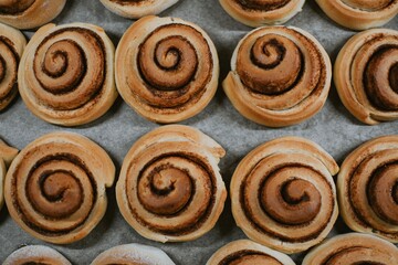 Close-up cinnabon buns freshly baked in the oven before applying cream in a cafe