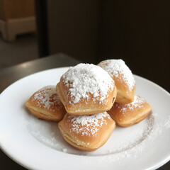 Unos muy ricos beignets en un plato blanco